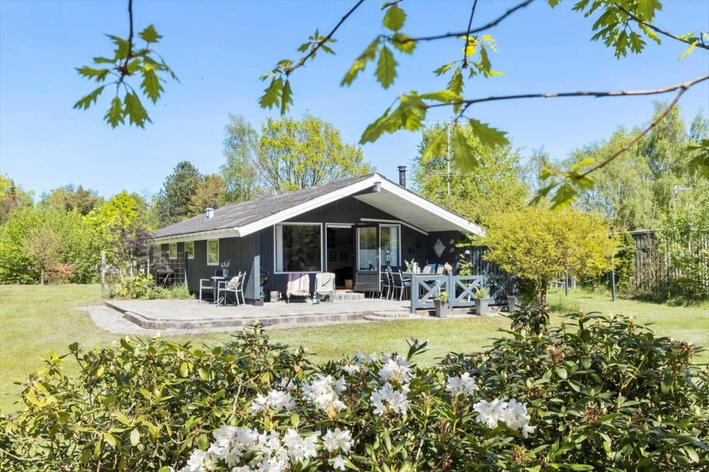 a cottage in a garden with flowers in the foreground at 8531-Grenaa-Annettevej-9 in Brøndstrup
