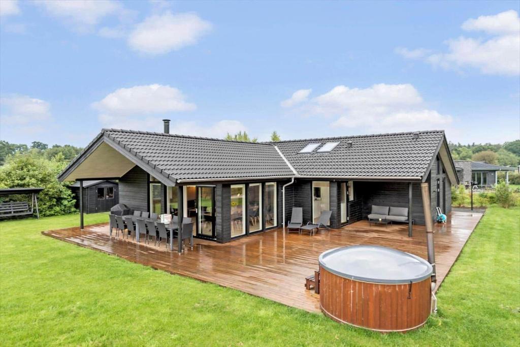 a house with a hot tub on a deck at 8846-Glesborg-Skovsoen-76 in Glesborg