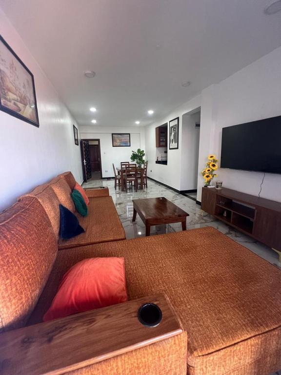 a living room with two couches and a flat screen tv at Three bedroom place with lake view in Kampala
