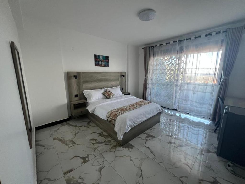 1 Schlafzimmer mit einem Bett mit Marmorboden in der Unterkunft Three bedroom place with lake view in Kampala