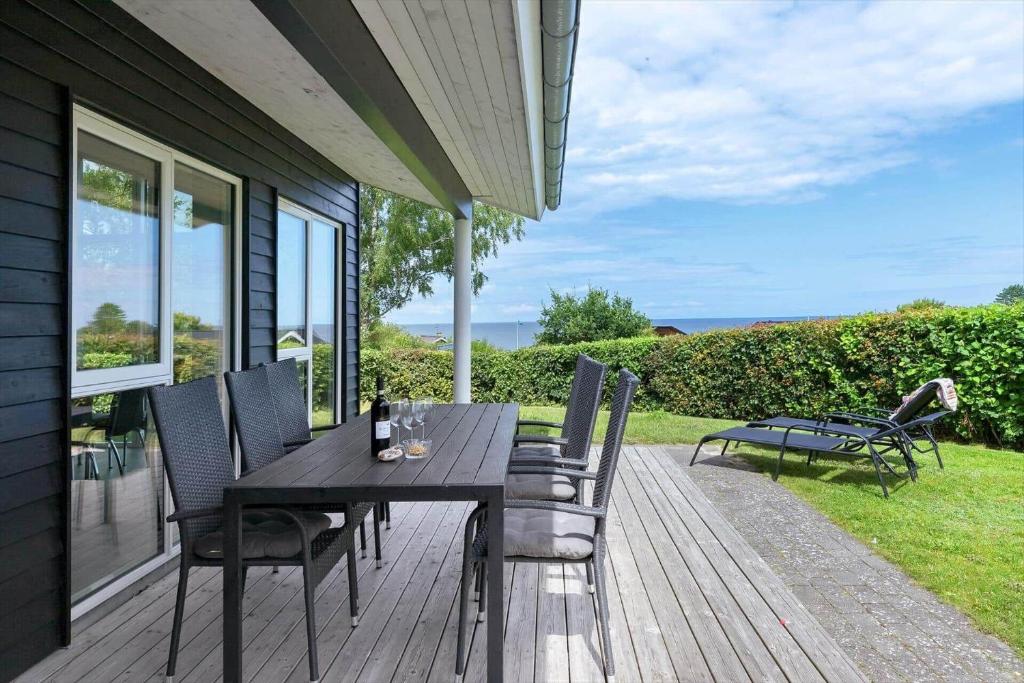 una terraza de madera con mesa y sillas en una casa en 8905-Allingabro-Rodklovervej-1, en Allingåbro