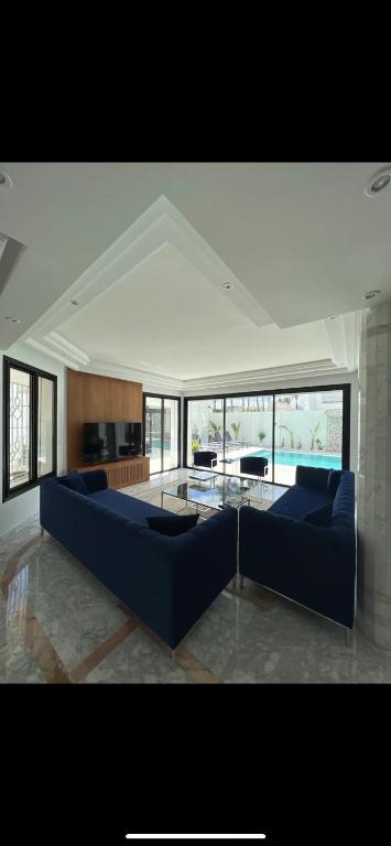 a living room with a blue couch and a table at Maison d'hôtes les berges du lac in Tunis