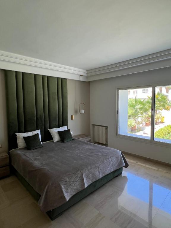 een slaapkamer met een groot bed met een groot raam bij Maison d'hôtes les berges du lac in Tunis
