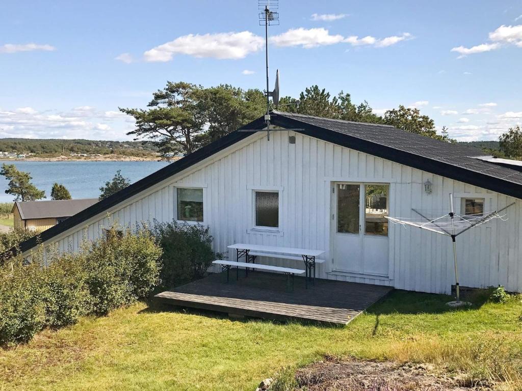 a white building with a bench on a wooden deck at 4 star holiday home in Åskloster in Åskloster