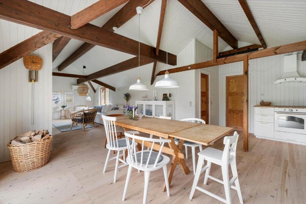 1619-Gilleleje-Ulvehojen-5 في جيليليه: مطبخ وغرفة طعام مع طاولة وكراسي خشبية