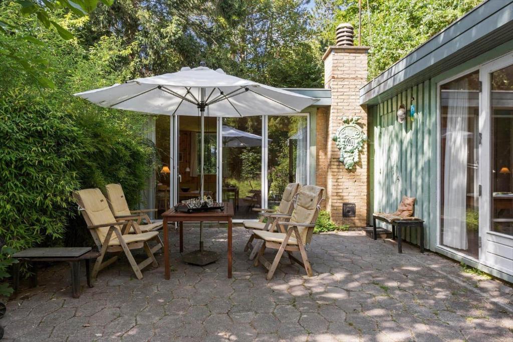 a patio with a table and chairs and an umbrella at 1601-Melby-Muldbjergvej-1 in Melby