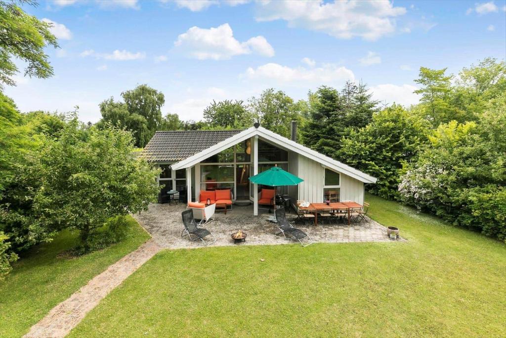 a small house with a table and chairs in a yard at 1481-N-Tisvildeleje-Bakkefrydvej-1 in Tisvildeleje