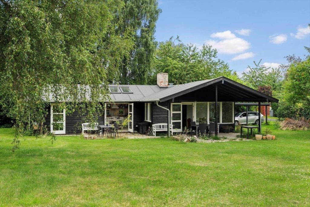 a house with a black tent in the yard at 1605-Dronningmolle-Tarnfalkevej-1 in Dronningmølle