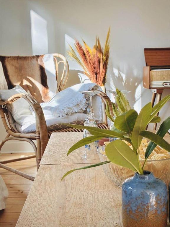 a table with a blue vase and a plant on it at 1645-Graested-Udsholt-Strandvej-101 in Græsted