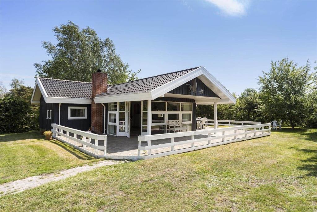 a small house with a large deck in a field at 617-N-Melby-Bakkely-8-B in Melby