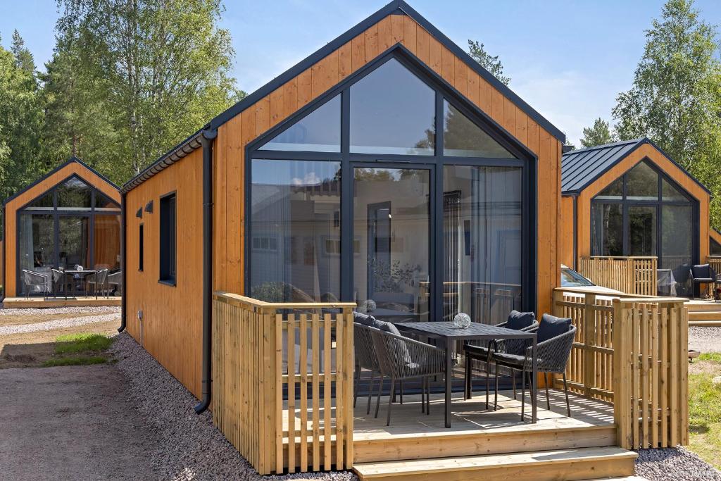 una gran casa de cristal con una mesa en la cubierta en First Camp Skara Sommarland, en Axvall