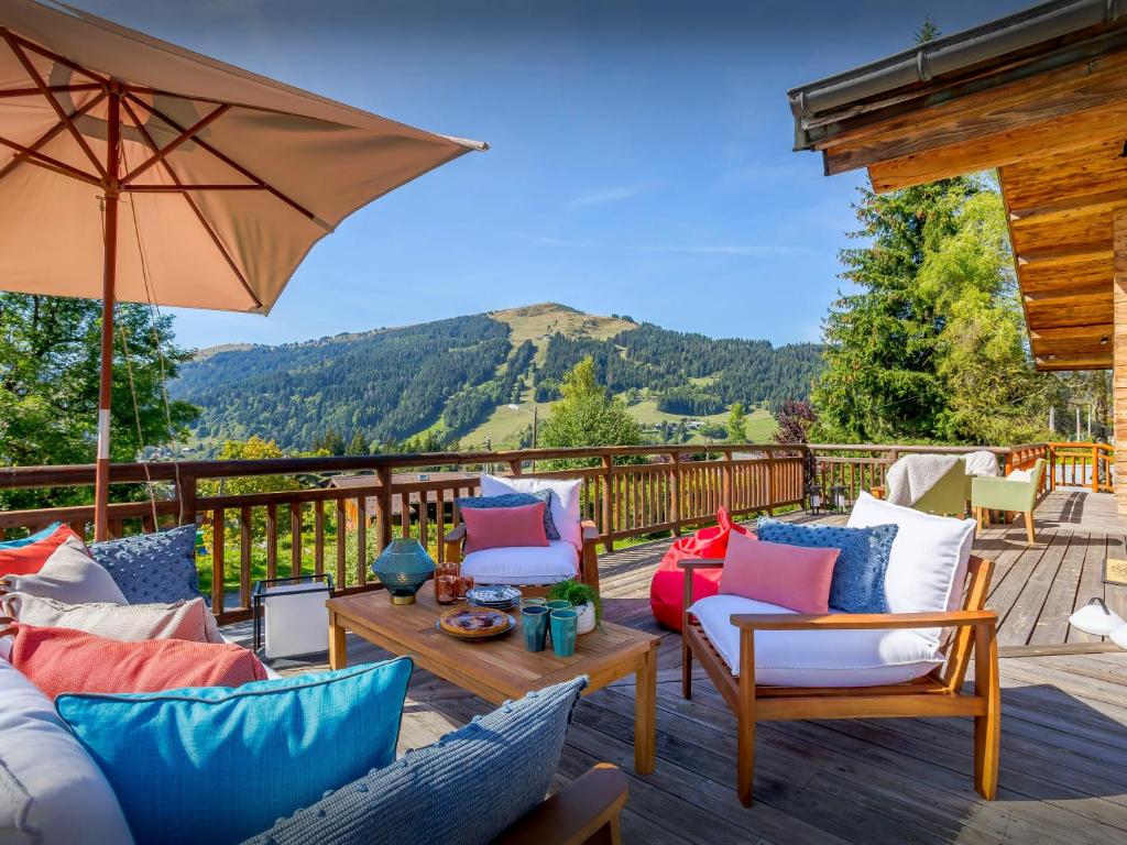 a patio with chairs and an umbrella and a table at Chalet Joux Verte - OVO Network in Les Gets