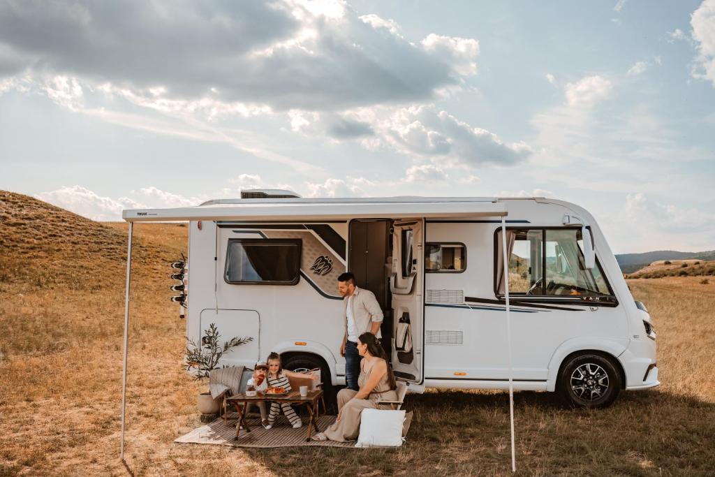 a group of people sitting outside of an rv at RWay The Moving Hotel by Theo in Budapest