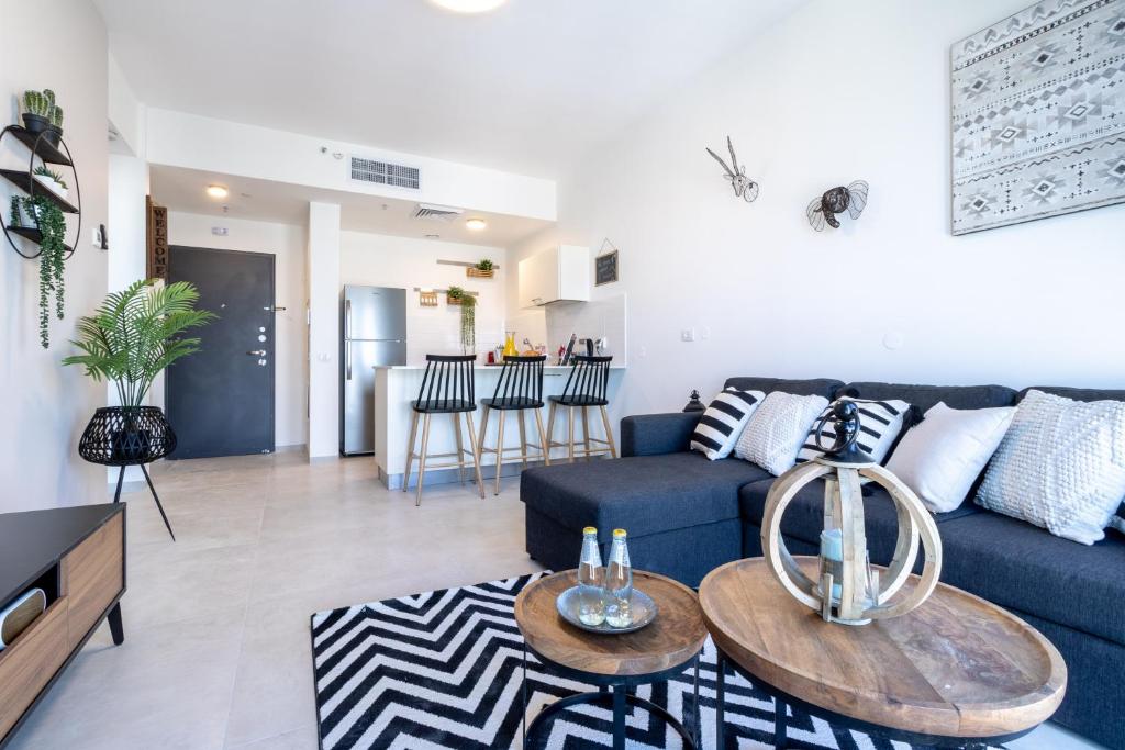 a living room with a blue couch and a table at New apartment in the heart of Jerusalem ! in Jerusalem