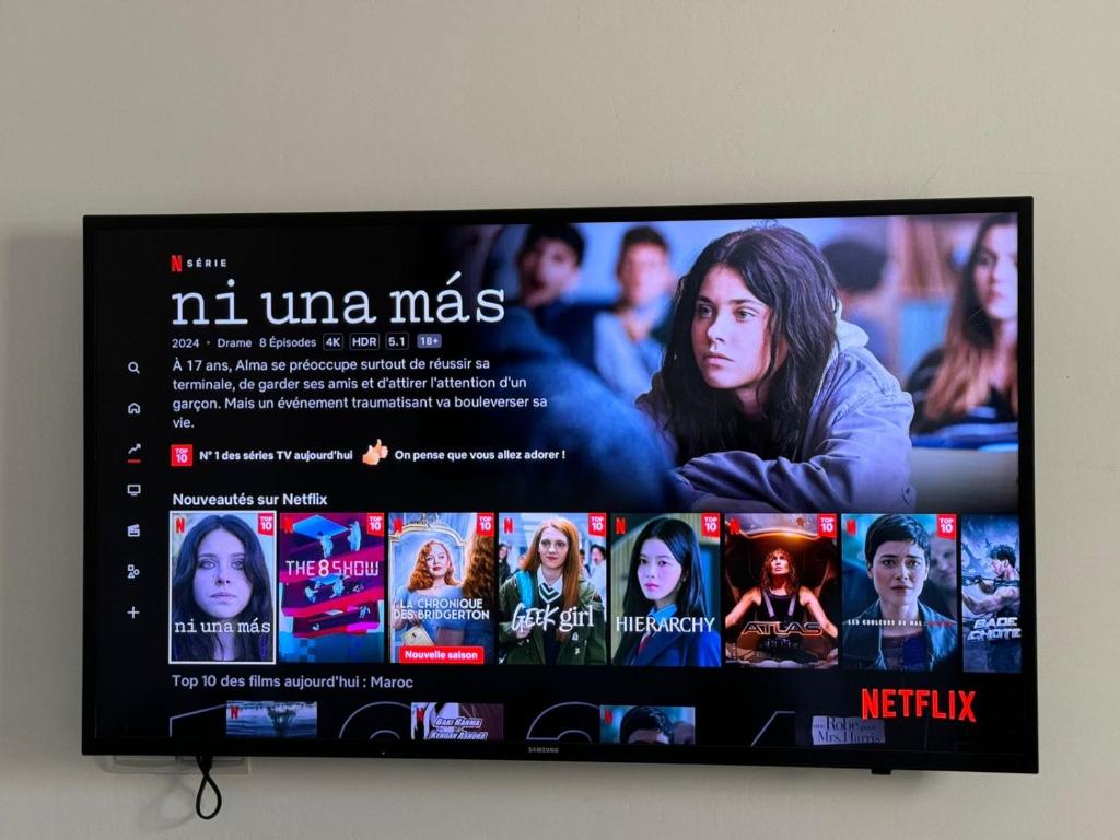 a flat screen tv with a movie on it at Apartment oasis moderne in Tangier