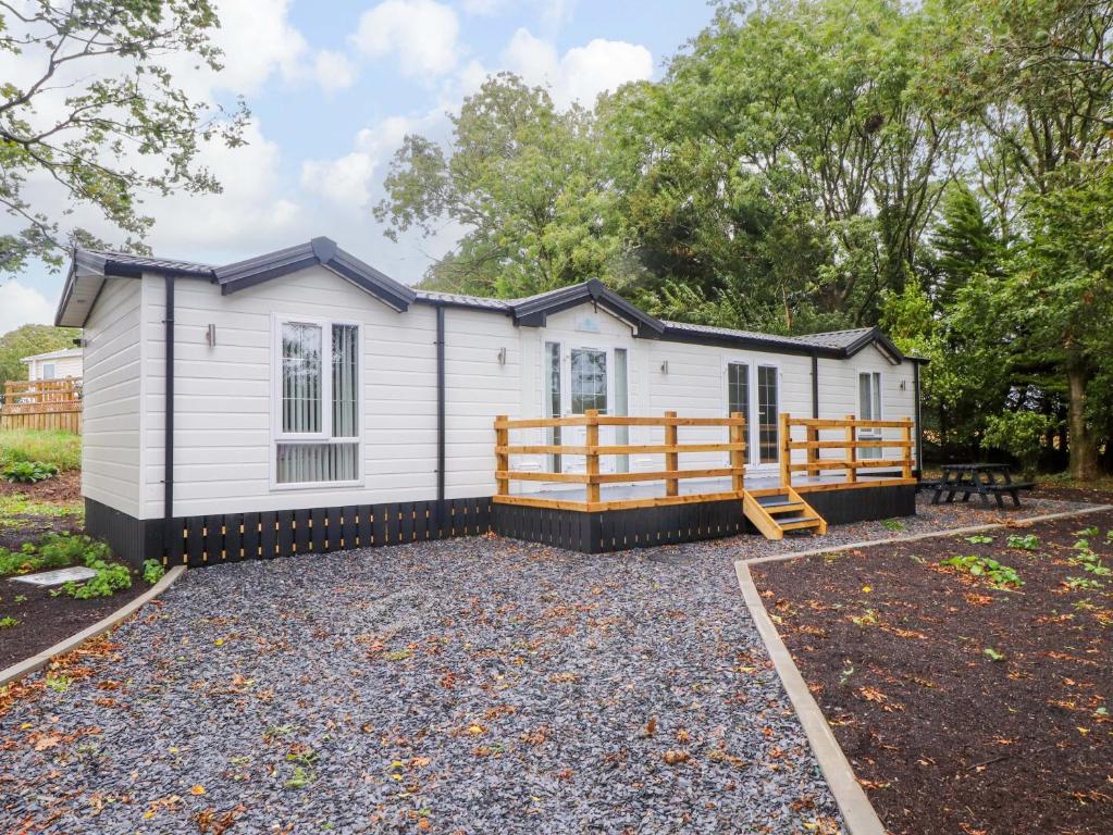 a tiny house with a porch and a deck at The Chalet at Tyn Lon in Pwllheli