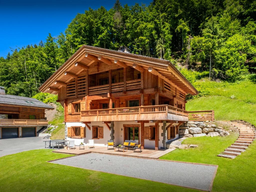 eine große Blockhütte mit Veranda und Terrasse in der Unterkunft Chalet Angelia - OVO Network in Le Grand-Bornand