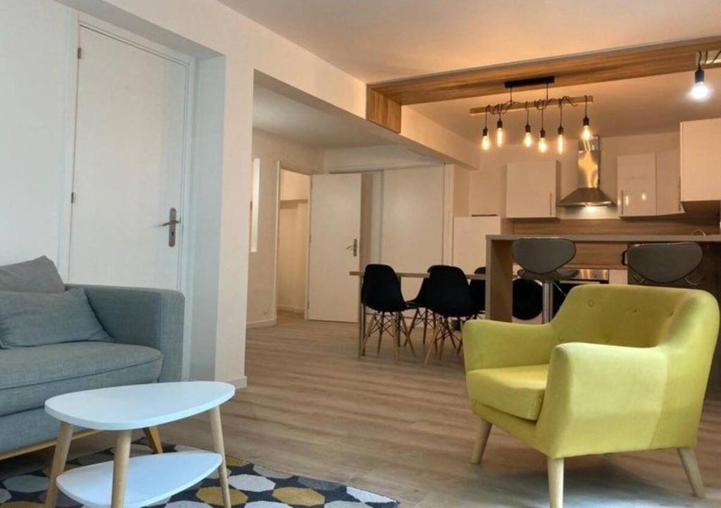 a living room with a couch and a table at Appartement avec Jardin aux portes de Genève in Ornex
