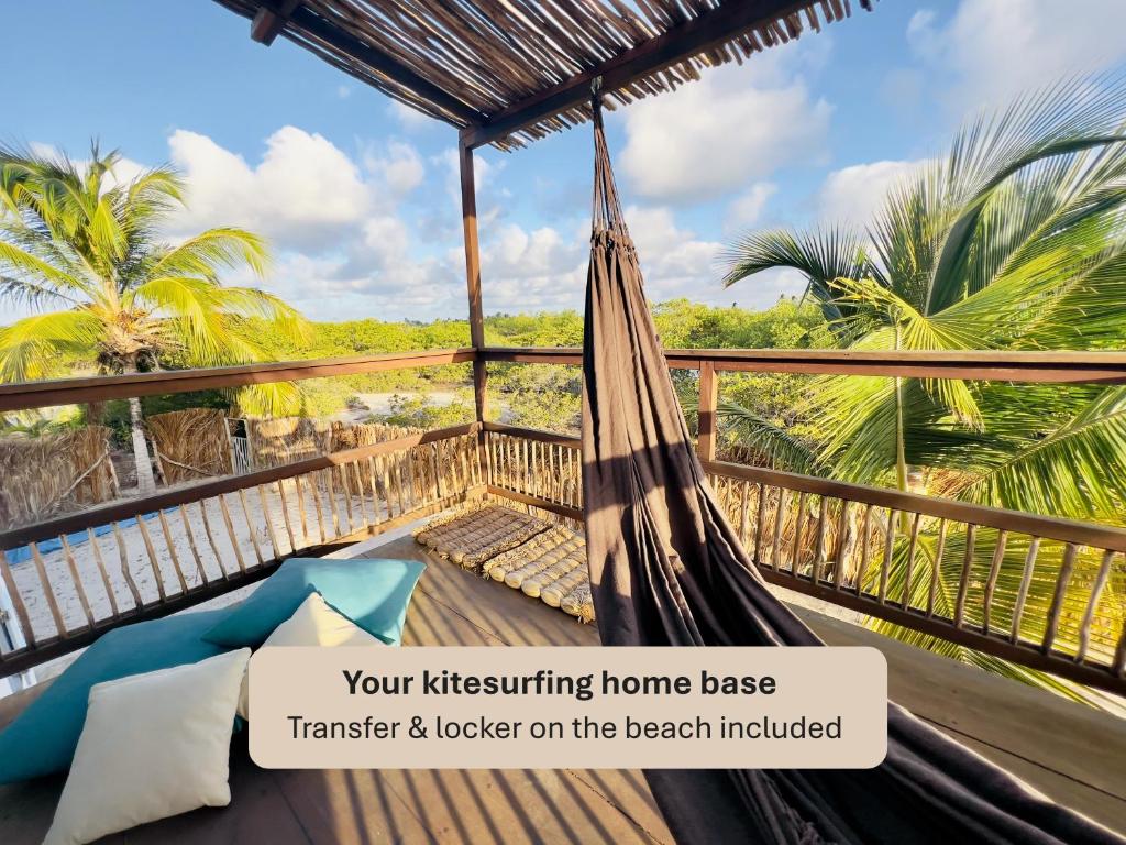 a hammock on the balcony of a beach house at Casa Celeste in Atins