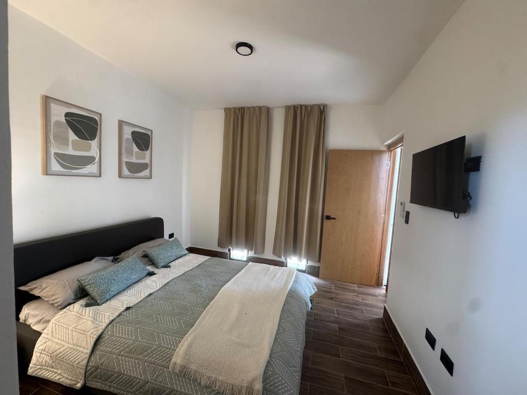 a bedroom with a bed and a flat screen tv at New & Chic 3-Bedroom Penthouse, Punta Cana, Pool-BBQ-Beach Access-Private Rooftop-Padel y Sports amenities in Punta Cana