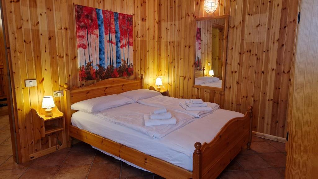 a bedroom with a large wooden bed with two lamps at Lavarone & Folgaria Residence in Lavarone