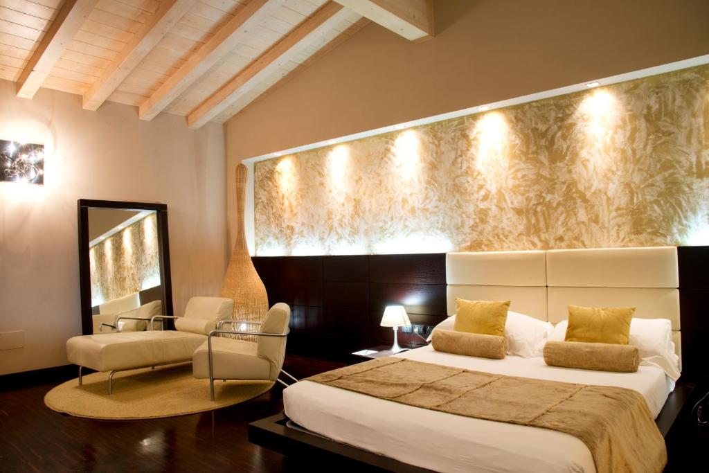 a bedroom with a king sized bed and a chair at OneMhotel in San Paolo