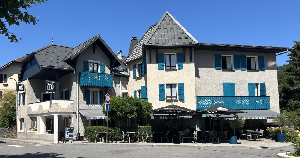 a large building with tables and chairs in front of it at Logis La Chaumière Saint-Maurice in Thorens-Glières