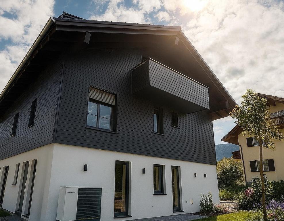 フィッシェン・イム・アルゴイにあるACHZEIT Family Retreat - Alpin-modernes Ferienhaus - 3 SZ - Garten - Kaminのバルコニー付きの白黒の家