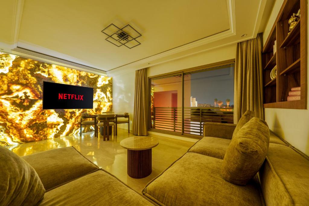 a living room with a couch and a tv at Kasbel 2 Appart & Pool in Marrakech