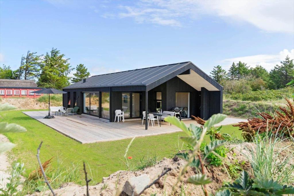 una casa con tetto nero e terrazza di BL1489-Blokhus-Paa-Bakken-8-B a Blokhus