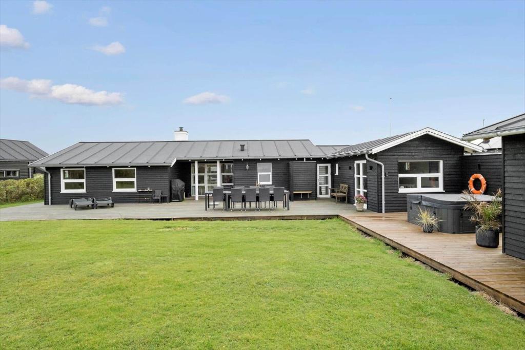 uma casa com um grande quintal na frente em BL709-Blokhus-Kr-Thomsensvej-5 em Blokhus