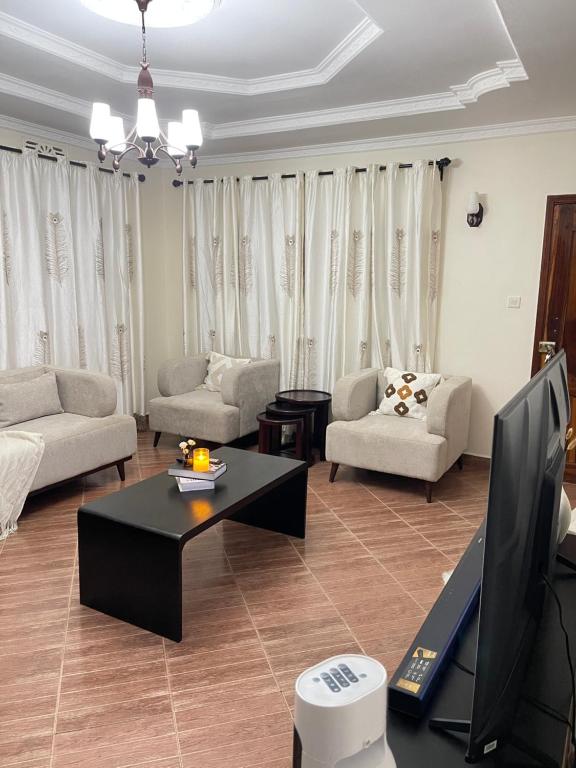 ein Wohnzimmer mit Sofa und Tisch in der Unterkunft Rhovee Arusha in Arusha