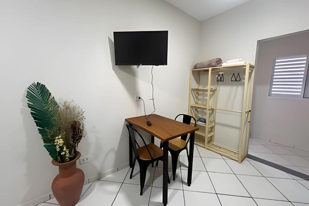 a room with a table and chairs and a tv at Studio kitnet Apartamento Privativo Jundiai 08 in Ermida
