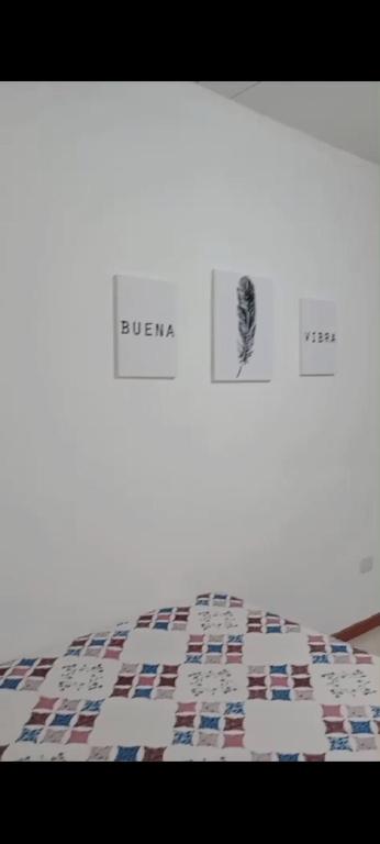 a close up of a bed with three pictures on it at Duplex Rawson in Gualeguaychú