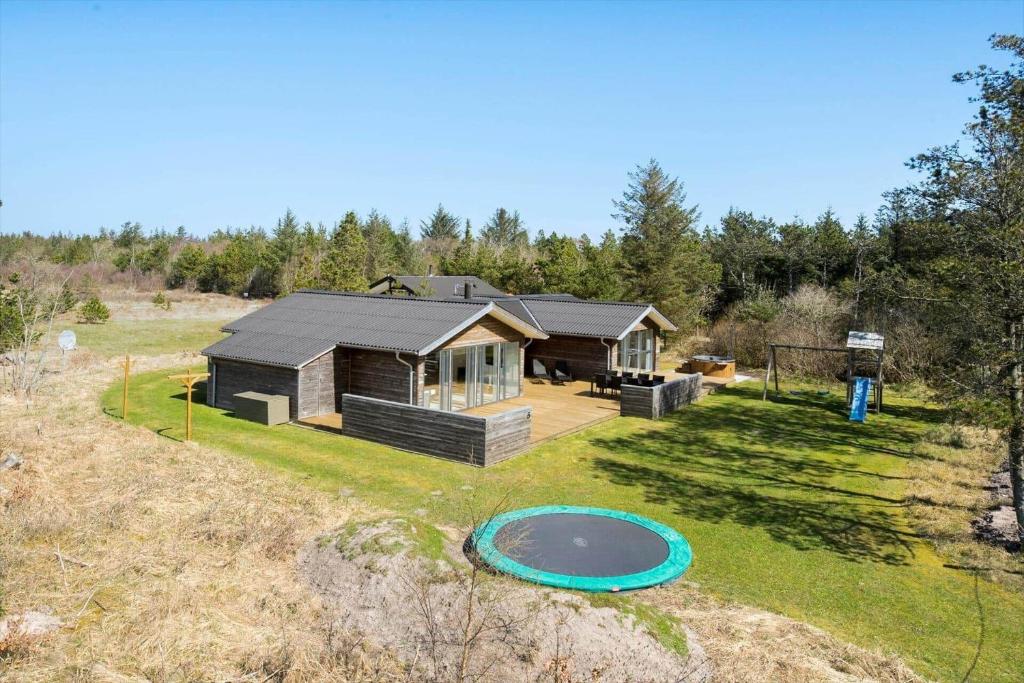 une petite maison avec un frisbee dans la cour dans l'établissement BL1236-Pandrup-Kirkekrogen-5, à Pandrup