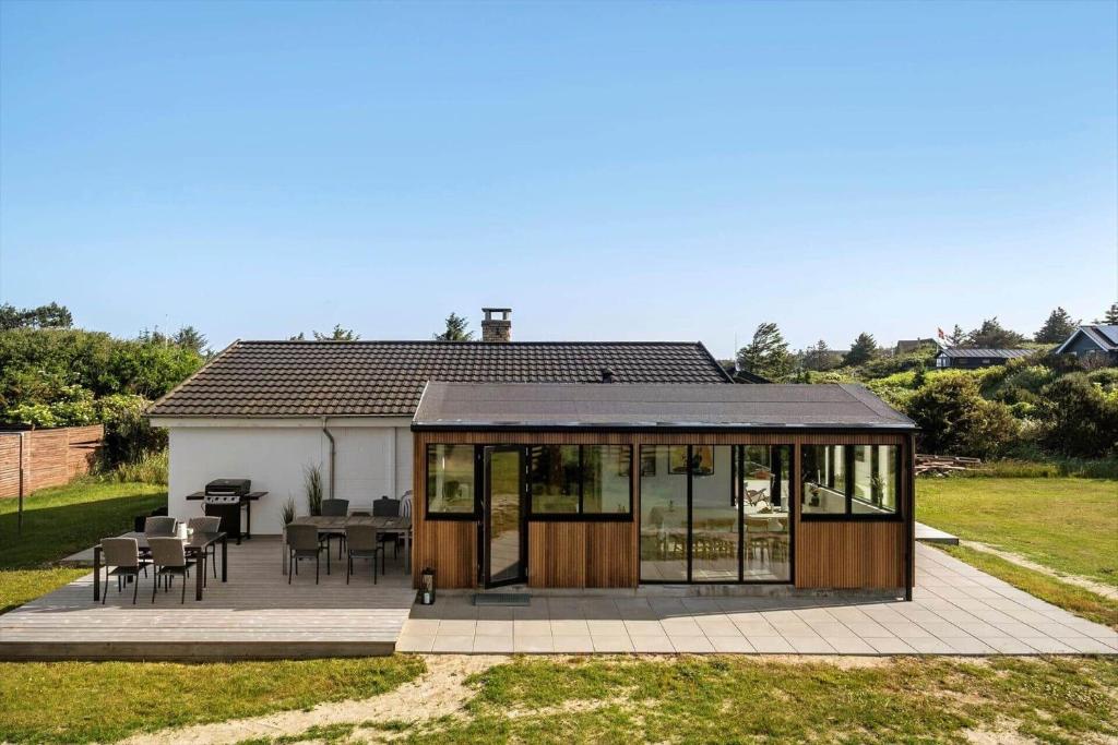 a small house with a deck and a patio at BL1275-Blokhus-Pirupshvarrevej-17 in Blokhus
