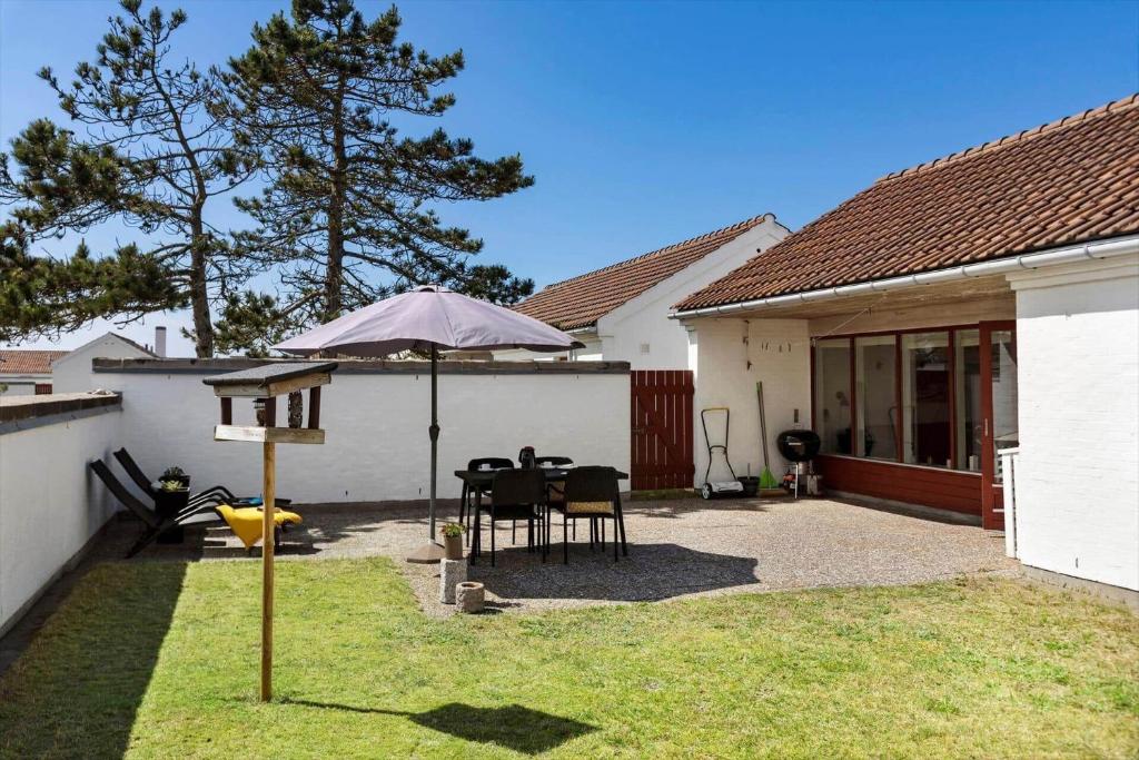 a patio with an umbrella and a table and chairs at BL1397-Pandrup-Rodhus-Klitvej-363 in Pandrup