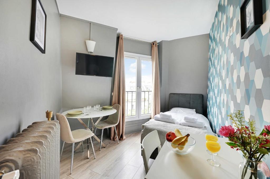 a room with a bed and a table and a bed and a dining room at Modern studio - 1P- Canal Saint-Martin in Paris