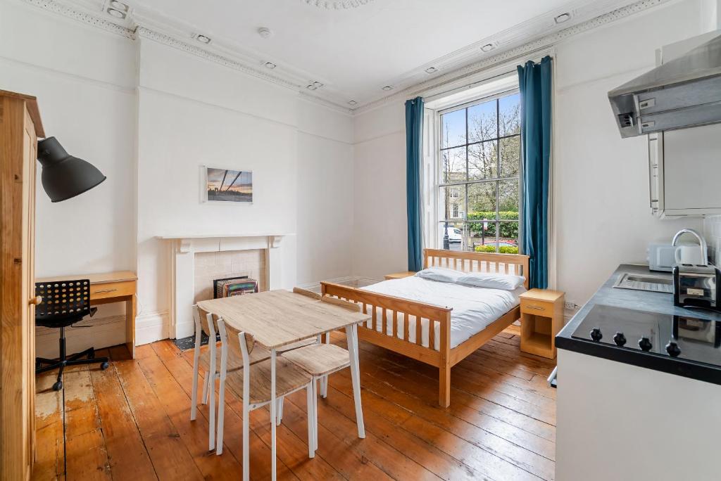 a kitchen with a bed and a table in a room at No 4 Georgian Shared House - By Clifton Short Lets in Bristol
