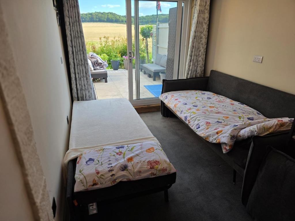 The Pod Quiet Sun Patio Fab Steam &Countryside Views في ويبورن: غرفة نوم بها سريرين ونافذة ذات إطلالة