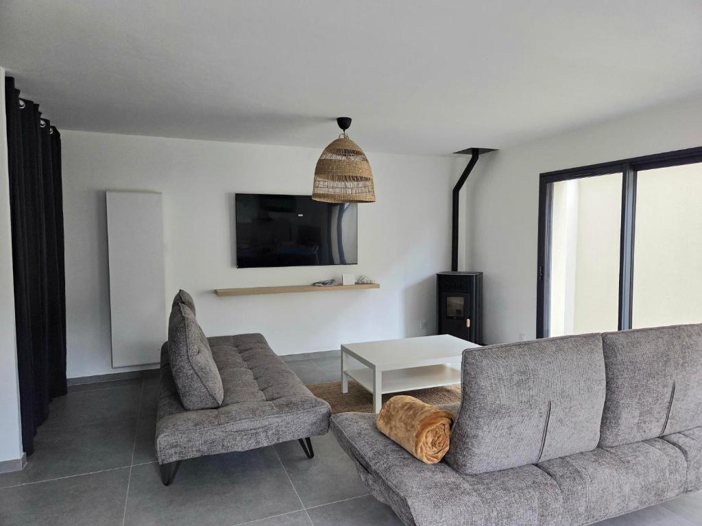 a living room with a couch and two chairs and a tv at Le chalet du Petit Ours Brun in Formiguères