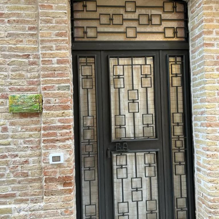 a black door with glass windows on a brick building at La casetta in Serracapriola