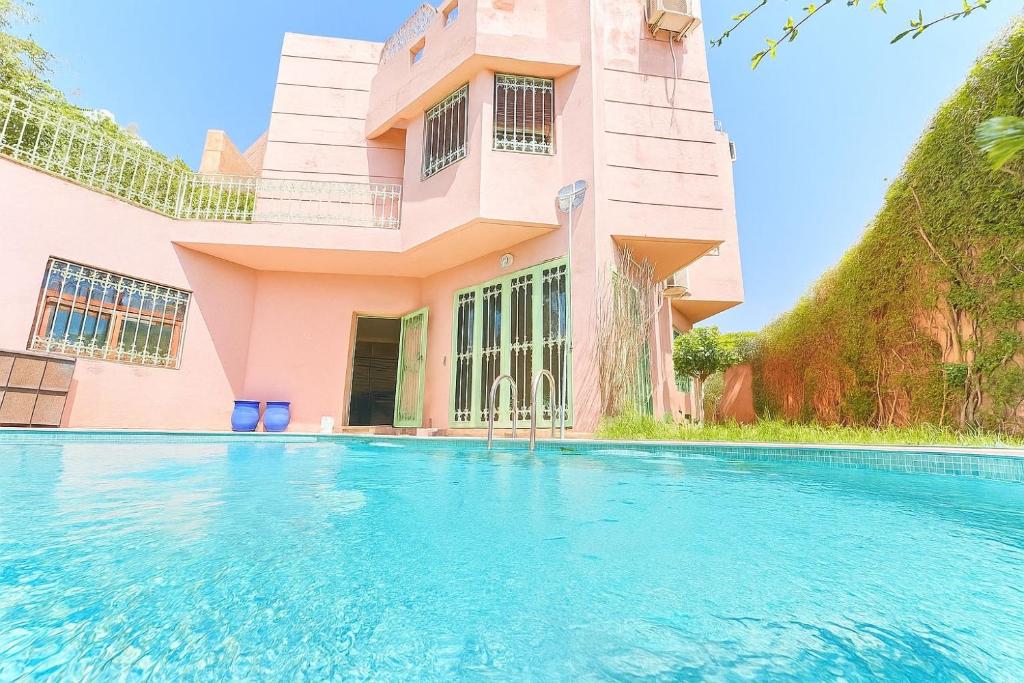 a house with a swimming pool in front of it at Élégante Villa 3 Chambres avec Jardin & Piscine Targa Afak Marrakech in Marrakech