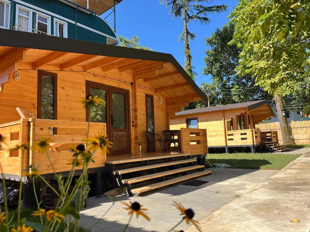 a log cabin with a porch and a bench at Solwood Cottage Ureki in Ureki