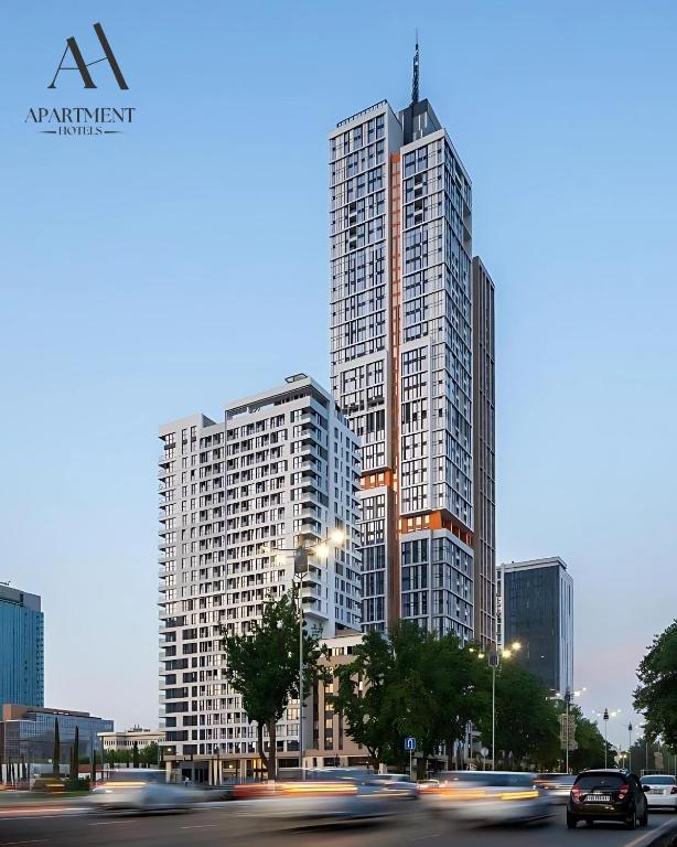 a tall building with cars in front of it at NestOne - Apartment hotels in Tashkent