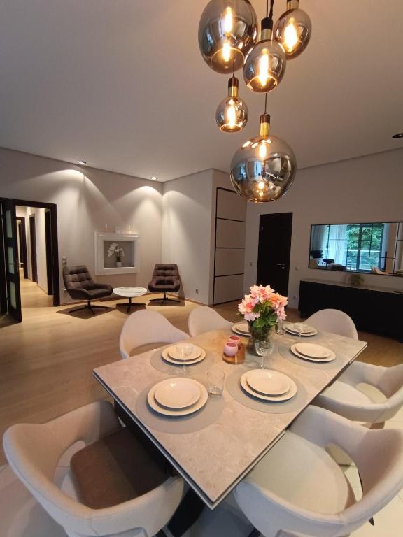 a dining room with a table and white chairs at First Line - Dzintaru prospekts Apartment in Jūrmala
