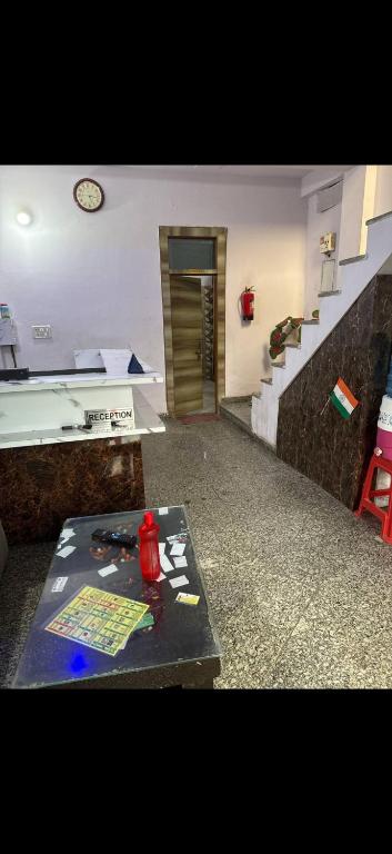 a room with a staircase and a table with a clock at Hotel IC TOWER in Noida