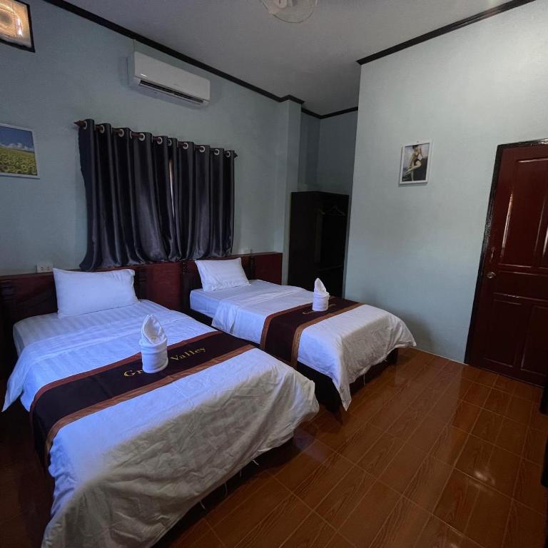 a room with two beds in a room at 万荣微笑酒店 in Vang Vieng