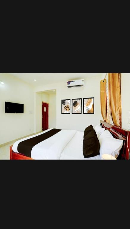 a bedroom with a large bed with white sheets at S G R Paradise in Chik Bānavar