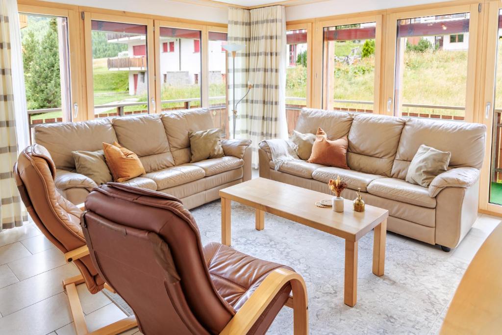 a living room with two couches and a coffee table at Haus Snow Fun B in Saas-Fee